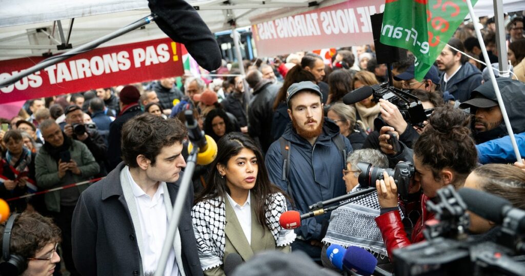 Rima Hassan s'adresse aux journalistes à côté de son avocat Vincent Brengarth (G) lors d'un rassemblement de soutien, à Paris le 30 avril 2024