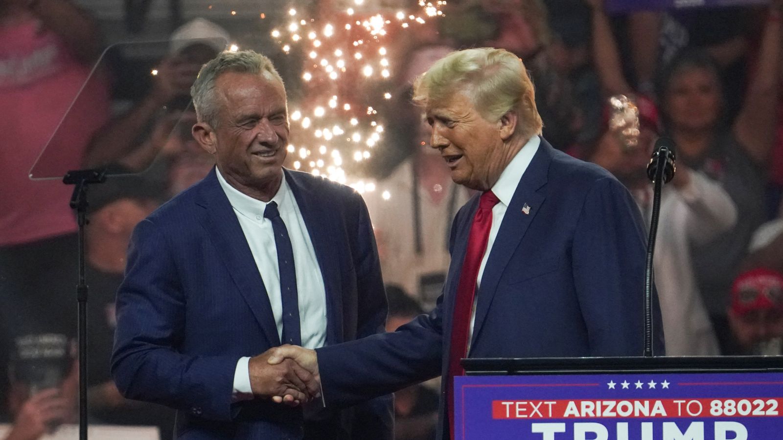 Republican presidential nominee and former U.S. President Donald Trump shakes hands with former independent presidential candidate Robert F. Kennedy Jr. during a rally in Glendale, Arizona, U.S., August 23, 2024. REUTERS/Go Nakamura