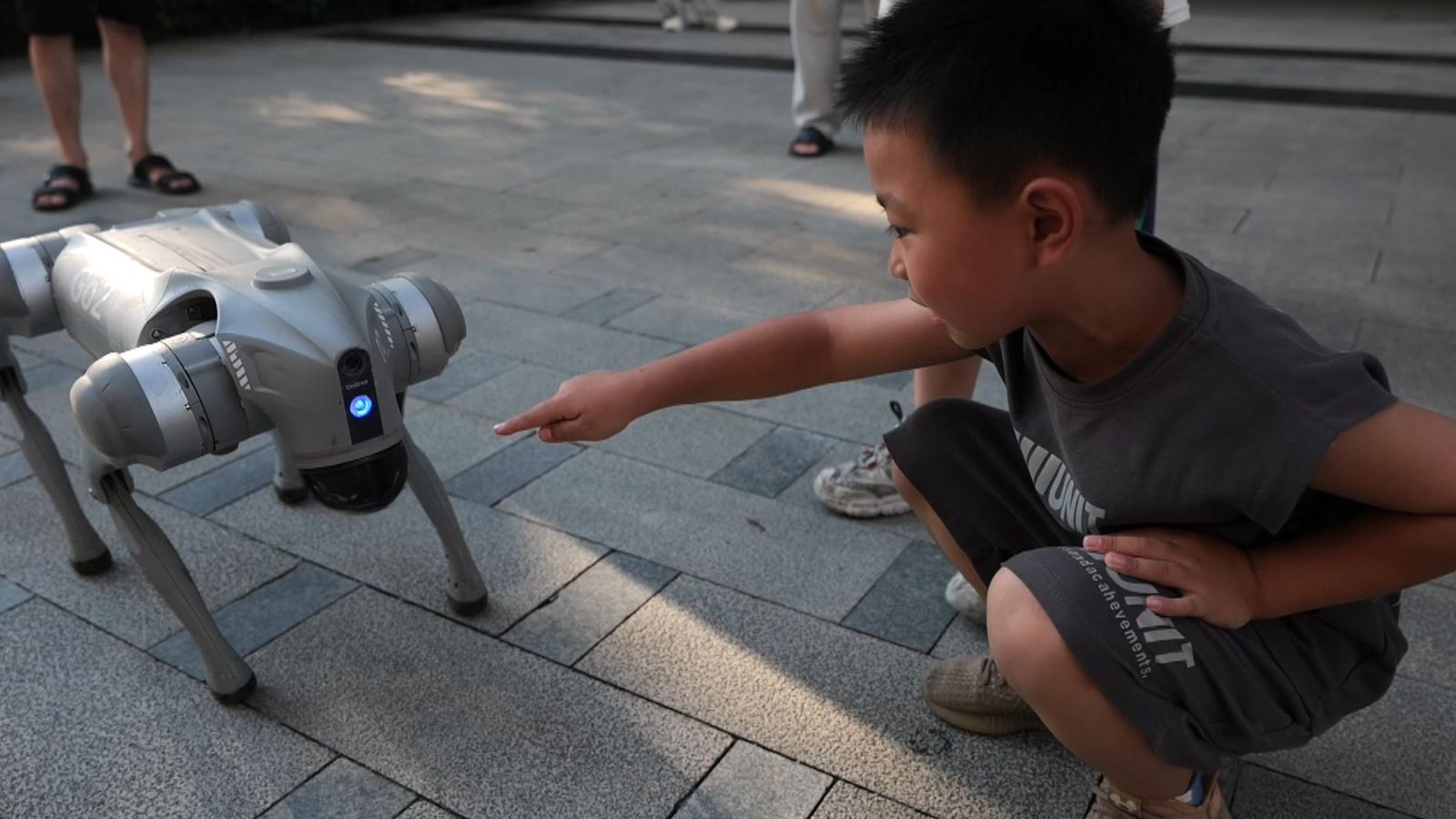 A child plays with a robot dog in China