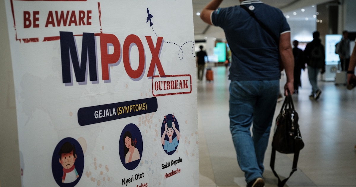 Un passager passe devant une bannière informant sur la variole du singe (MPOX) à l'aéroport international Soekarno-Hatta de Tangerang, le 26 août 2024.