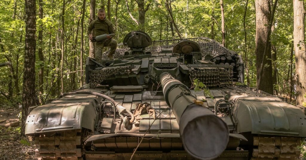 Un militaire ukrainien porte un obus d'un char T-72 de fabrication soviétique, dans la région de Soumy, près de la frontière avec la Russie, le 12 août 2024