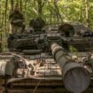 Un militaire ukrainien porte un obus d'un char T-72 de fabrication soviétique, dans la région de Soumy, près de la frontière avec la Russie, le 12 août 2024