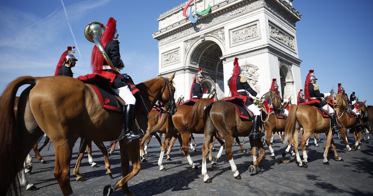 Le régiment de cavalerie de la Garde républicaine française arrive pour se préparer au défilé militaire du Jour de la Bastille sur l'avenue Foch, avec l'Arc de Triomphe en arrière-plan, à Paris, le 14 juillet 2024