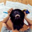 Top view of stressed young sitting Asian woman hands holding the head worry about find money to pay credit card debt and all loan bills. Financial problem concept. (GDA via AP Images)