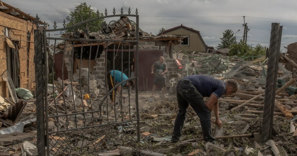 Des habitants dans les débris à proximité de maisons lourdement endommagées après un bombardement à Pokrovsk, dans la région de Donetsk, le 24 juin 2024 en Ukraine