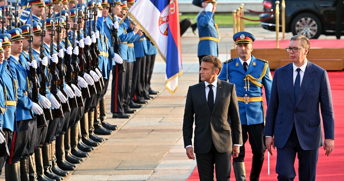 Le président français Emmanuel Macron et son homologue serbe Aleksandar Vucic (d) passent en revue la garde d'honneur, le 29 août 2024 à Belgrade