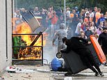 Balaclava-clad baying mob storm migrant hotel, hurl chairs at riot police and set fire to furniture while terrified asylum seekers watch on from rooms in latest violent riots