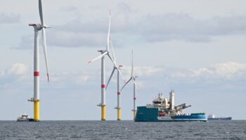 Une éolienne et une sous-station électrique sont photographiées sur le premier parc éolien offshore français au large de La Turballe, dans l'ouest de la France, le 30 septembre 2022. Le parc, composé de 80 éoliennes, fournira 480 MW, pour un investissement de 2 milliards d'euros (Photo Damien MEYER / AFP)