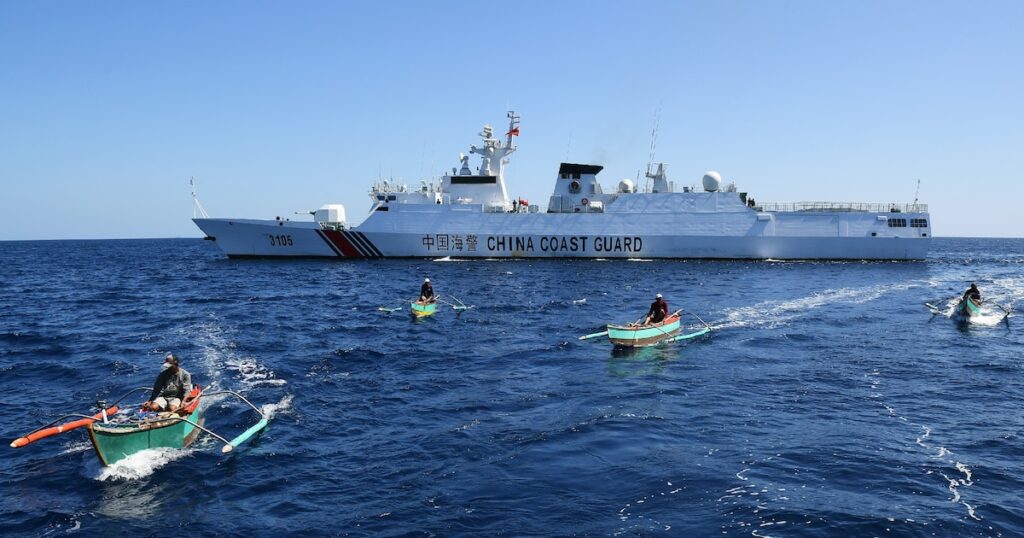 Des pêcheurs philippains devant un navire militaire chinois au large du récif de Scraborough, un îlot contrôlé par la Chine mais revendiqué par les Philippines, le 15 février 2024