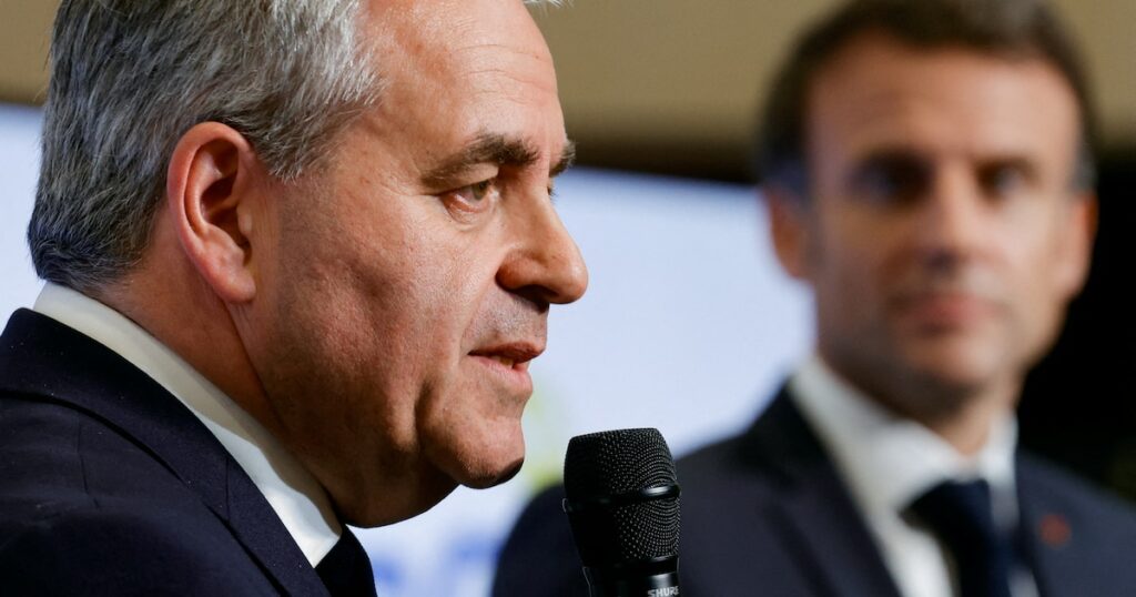 President of the Regional Council of Hauts-de-France Xavier Bertrand (L) speaks next to French President Emmanuel Macron at the Dunkirk Urban Community offices in Dunkerque, the city picked by Taiwanese company ProLogium to build a battery gigafactory plant, northern France, on May 12, 2023. (Photo by PASCAL ROSSIGNOL / POOL / AFP)