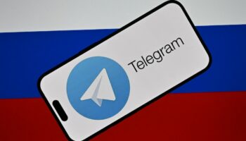 Le logo de la messagerie Telegram devant le drapeau russe.