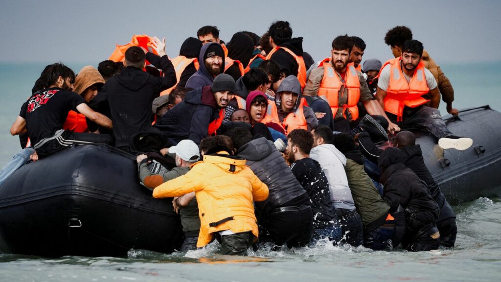 Migrants attempting to cross the English Channel to reach Britain get on an inflatable dinghy as the French police and gendarmes officers patrol on the beach of the Slack dunes in Wimereux, France, September 4, 2024. REUTERS/Benoit Tessier TPX IMAGES OF THE DAY