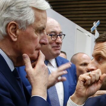 Le Président Emmanuel Macron (d) s'entretient avec le commissaire européen Michel Barnier (g) lors du salon de l'Agriculture le 23 février 2019