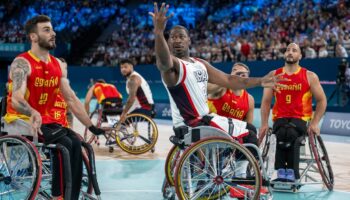 L'Américain Brian Bell (c) passe le ballon sous le regard de L'Espagnol Manuel Lorenzo (g) pendant le tour préliminaire du groupe B du match de basket-ball en fauteuil roulant entre les États-Unis et l'Espagne pendant les Jeux paralympiques de Paris 2024 à Paris, le 29 août 2024