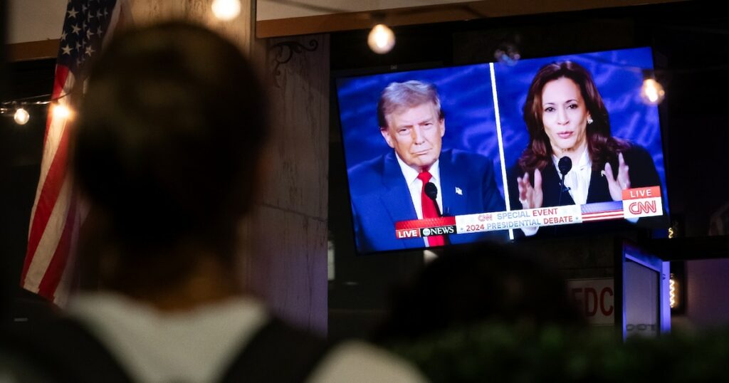 Un passant devant un bar à Washington diffusant le débat entre Donald Trump et Kamala Harris, le 10 septembre 2024