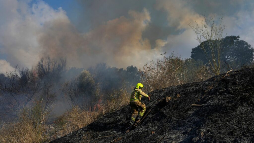 A firefighter works in the area around a fire after the military said it fired interceptors at a missile launched from Yemen that landed in central Israel on Sunday, Sept. 15, 2024. (AP Photo/Ohad Zwigenberg)