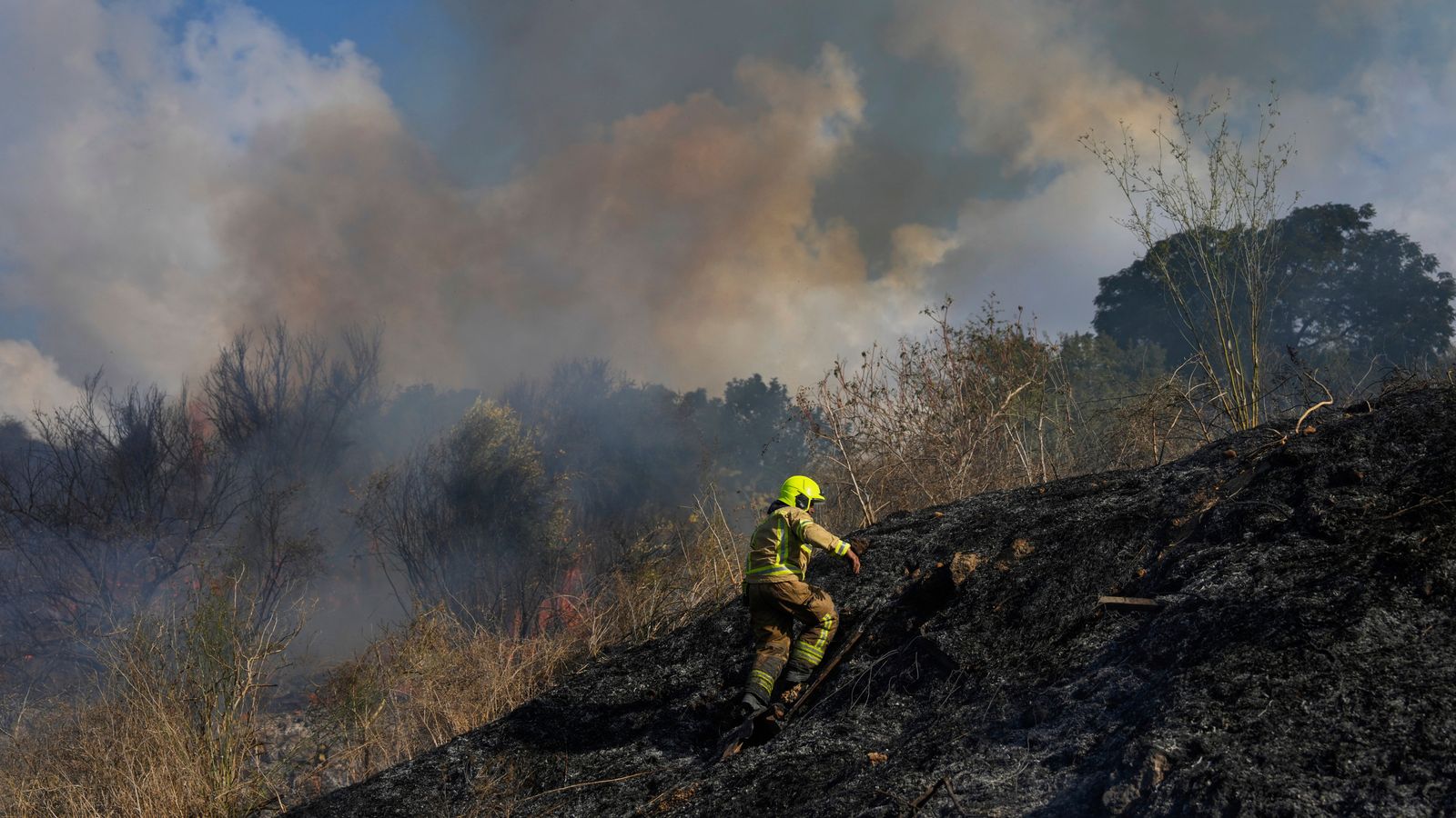 A firefighter works in the area around a fire after the military said it fired interceptors at a missile launched from Yemen that landed in central Israel on Sunday, Sept. 15, 2024. (AP Photo/Ohad Zwigenberg)