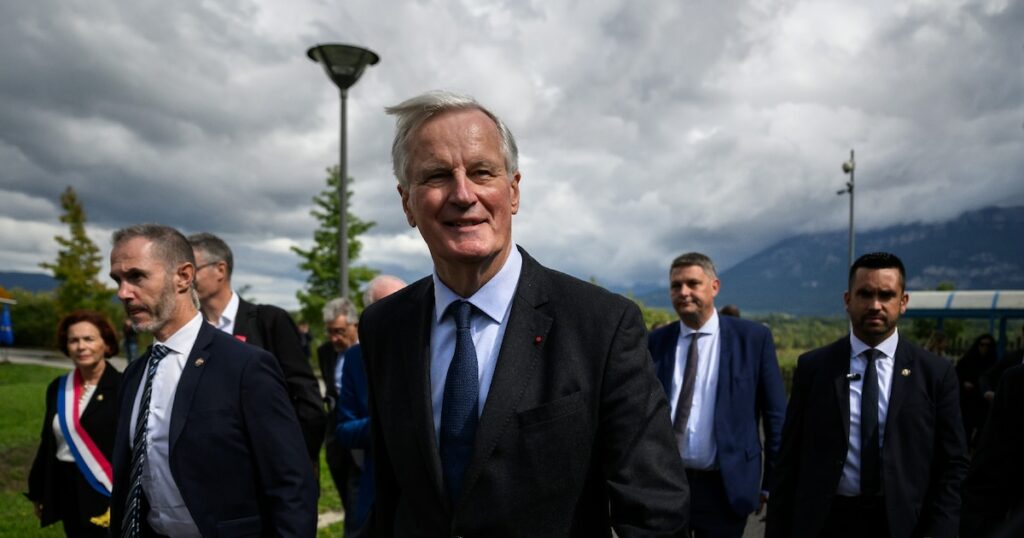 Le Premier ministre Michel Barnier (c) après une viste à l'Institut national de l'énergie solaire (Ines) au Bourget-du-Lac, le 12 septembre 2024 en Savoie