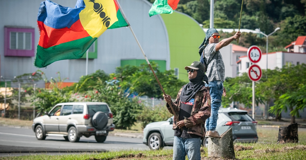 Des partisans de l'indépendance de la Nouvelle-Calédonie agitent des drapeaux sur le bord d'une route aà Nouméa, le 27 juin 2024