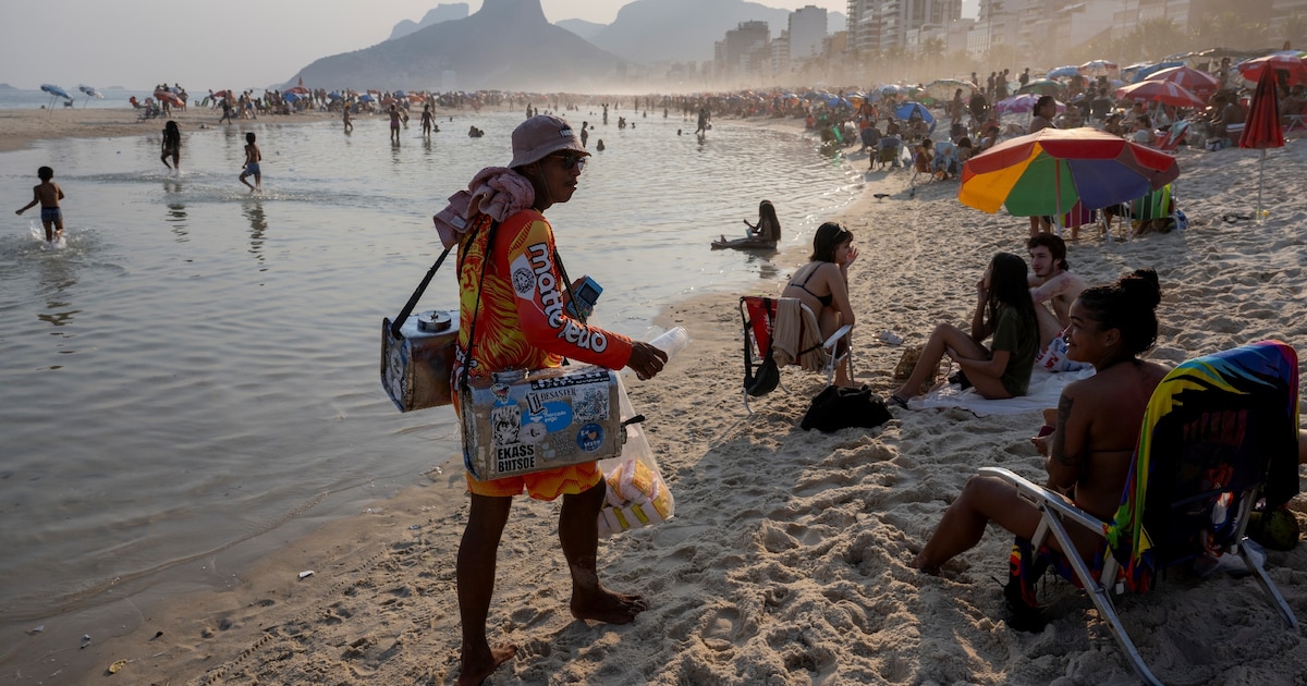 Un vendeur ambulant propose du thé au maté sur la plage d'Ipanema, à Rio de Janeiro, au Brésil, le 8 août 2024