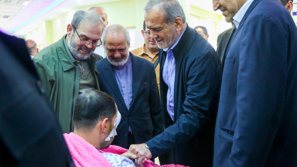 In this photo released by the Iranian Presidency Office, President Masoud Pezeshkian, second right, visits a victim of Lebanon's recent attacks at a hospital in Tehran, Iran, Friday, Sept. 20, 2024. (Iranian Presidency Office via AP)