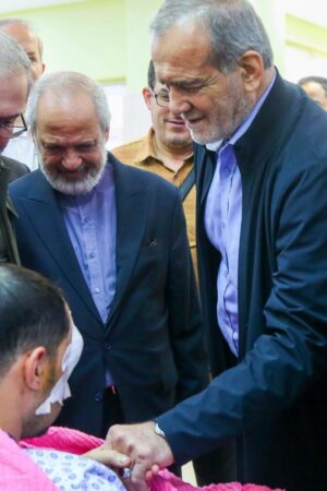 In this photo released by the Iranian Presidency Office, President Masoud Pezeshkian, second right, visits a victim of Lebanon's recent attacks at a hospital in Tehran, Iran, Friday, Sept. 20, 2024. (Iranian Presidency Office via AP)