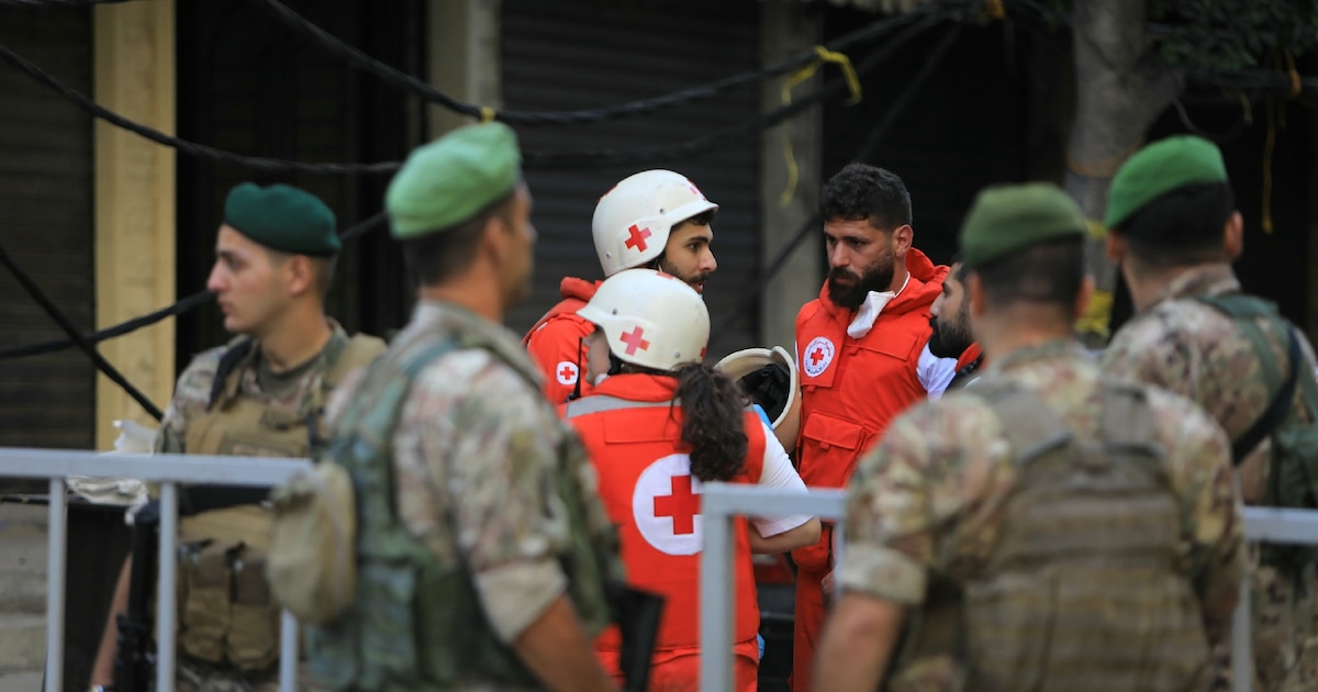 Secouristes et soldats libanais rassemblés sur les lieux de la frappe israélienne de la veille sur la banlieue sud de Beyrouth, le 21 septembre 2024