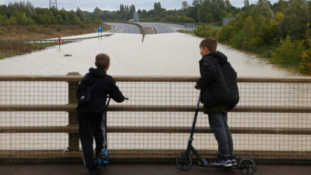 Young people look toward the A421 dual carriageway road after it was flooded following heavy rain, at Marston Moretaine near Bedford, Britain, September 23, 2024. REUTERS/Toby Melville