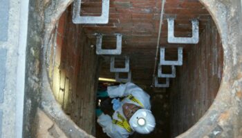 A Thames Water employee climbs down into a sewage pipe in London. File pic: PA