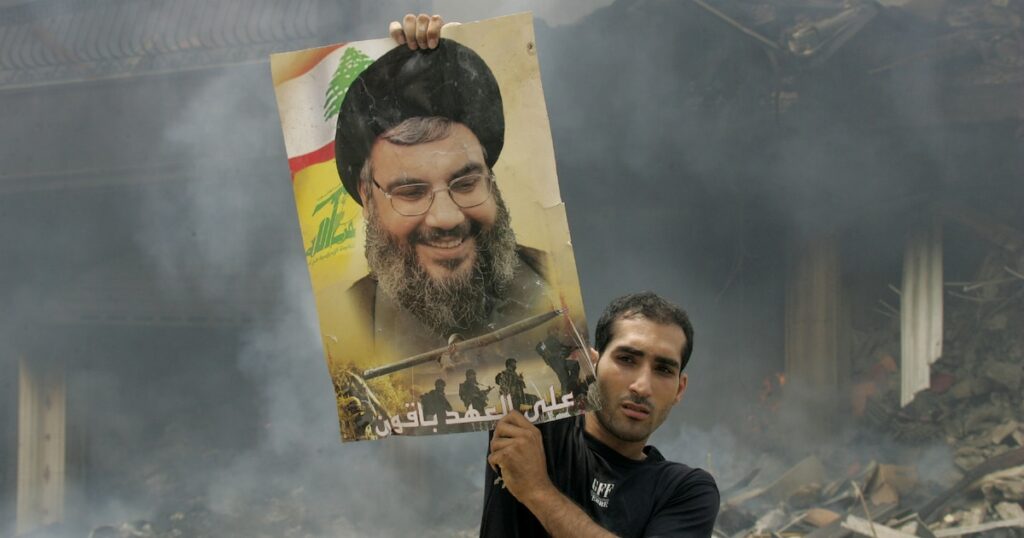 Un Libanais brandit une photo de Hassan Nasrallah après des frappes aériennes israéliennes sur un bastion du Hezbollah à Beyrouth, le 23 juillet 2006