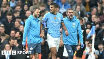 Rodri is helped from the pitch by Manchester City medical staff