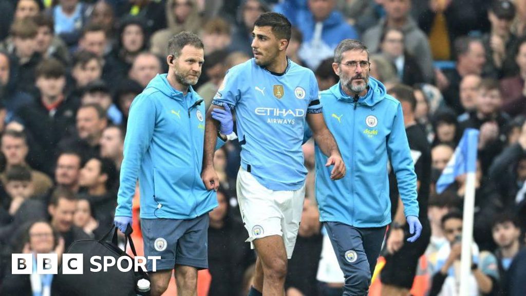 Rodri is helped from the pitch by Manchester City medical staff