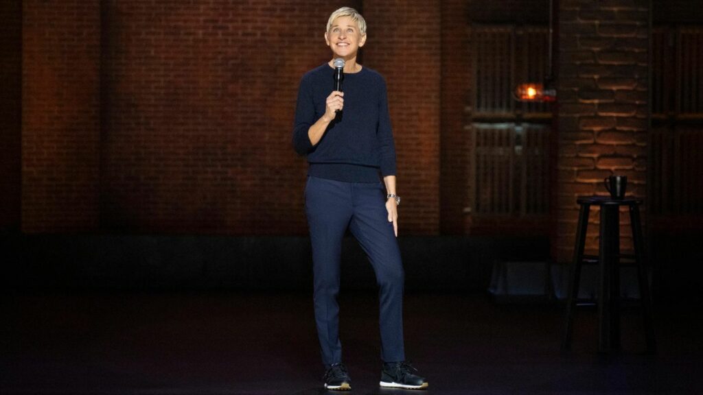 Ellen DeGeneres steht auf einer Bühne und hält ein Mikrophon in der Hand