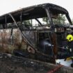 Firefighters work to extinguish a burning bus that was carrying teachers and students from Wat Khao Phraya school