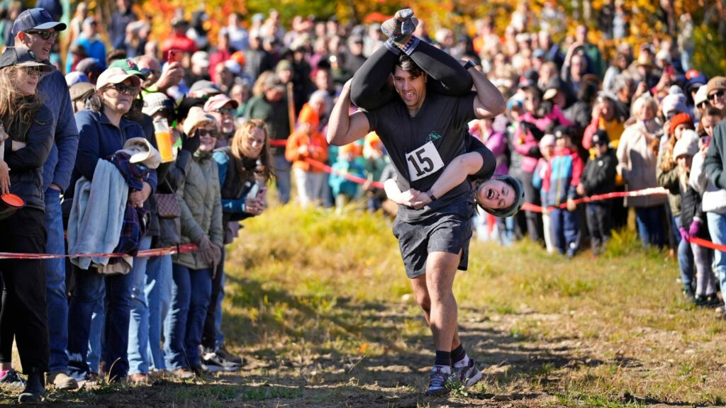 Nic Vinsonhaler carries Tara Rogowski while competing in the North American Wife Carrying Championship. Pic: AP Photo/Robert F Bukaty