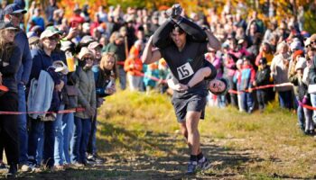 Nic Vinsonhaler carries Tara Rogowski while competing in the North American Wife Carrying Championship. Pic: AP Photo/Robert F Bukaty