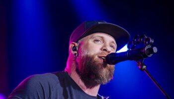 Country star Brantley Gilbert pauses concert as wife gives birth on tour bus – then returns to finish show