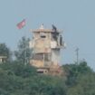 FILE - North Korean soldiers work at the North's military guard post as a North Korean flag flutters in the wind, are seen from Paju, South Korea, near the border with North Korea, Thursday, Oct. 10, 2024. (AP Photo/Ahn Young-joon, File)