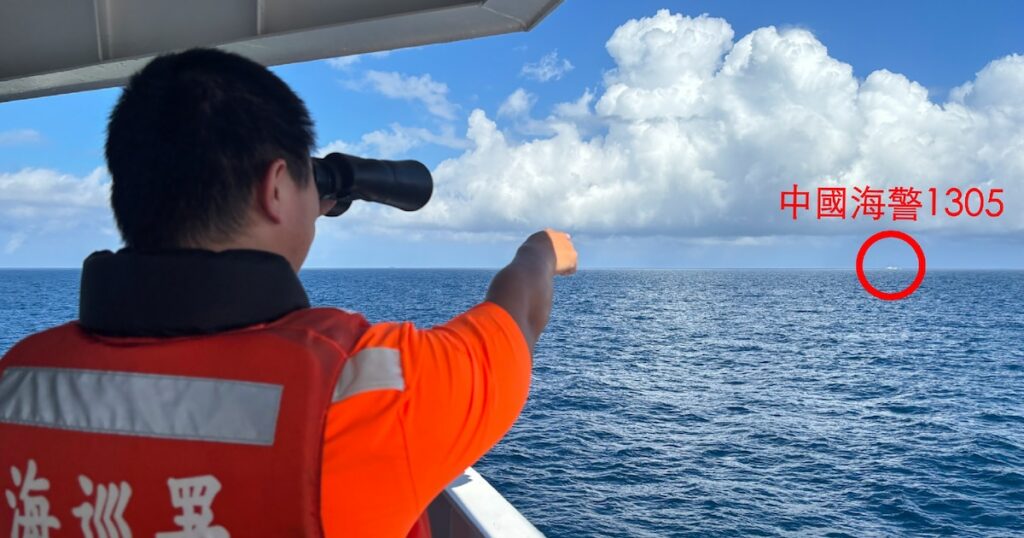 Photo diffusée par les gardes-côtes taïwanais, le 14 octobre 2024, d'un garde-côte taïwanais, sur un navire pétrolier au large de l'îlot Pengjia, observant aux jumelles un navire des gardes-côtes chinois naviguant en dehors des eaux territoriales de Taïwan