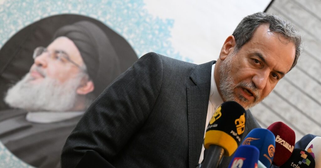 Le ministre iranien des Affaires étrangères, Abbas Araghchi, s'adresse à la presse à Damas, avec en arrière plan un portrait du chef du Hezbollah tué, Hassan Nasrallah, le 5 octobre 2024