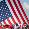 Le drapeau américain flotte au dessus de sympathisants venus assister au meeting où Donald Trump a été la cible de tirs à Butler (nord-est des Etats-Unis), le 13 juillet 2024