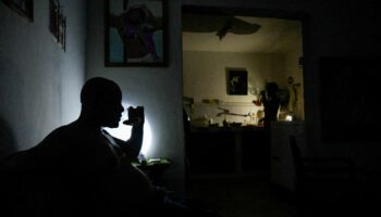 FILE PHOTO: A man drinks water at his home during a power outage caused by breakdowns forcing six plants to go off-line on the grid, according to the state run power company, in Matanzas, Cuba August 22, 2024. REUTERS/Norlys Perez/File Photo