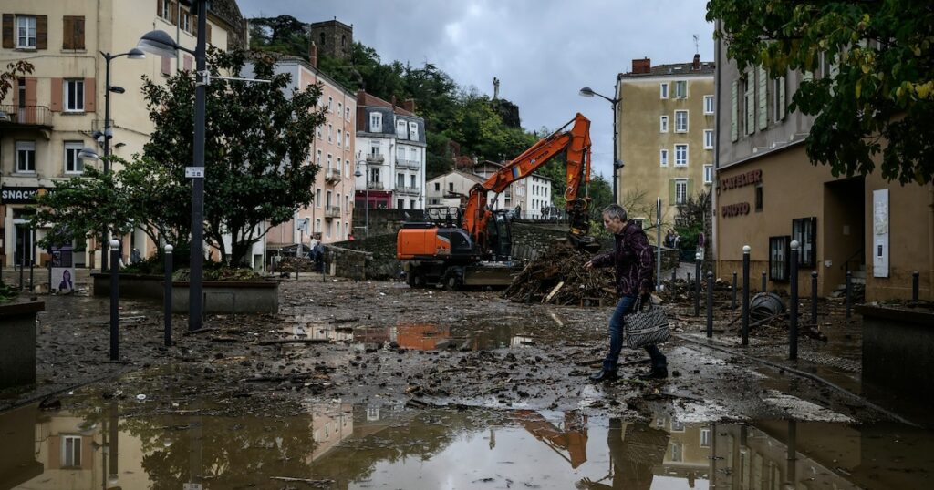 Un habitant traverse une rue inondée d'Annonay, en Ardèche, le 17 octobre 2024