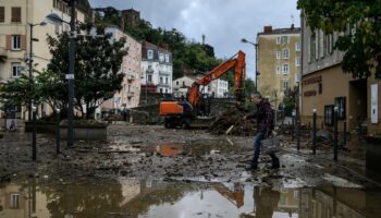 Un habitant traverse une rue inondée d'Annonay, en Ardèche, le 17 octobre 2024