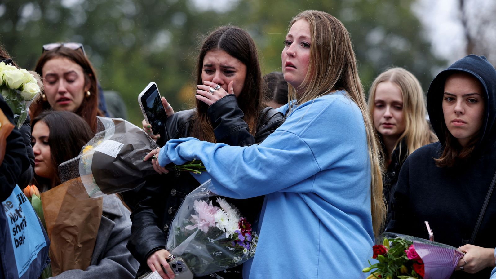 Fans comfort one another at the London vigil on Sunday. Pic: Reuters