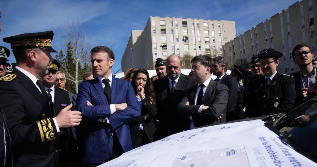 Le président Emmanuel Macron (2e g) et le préfet de police des Bouches-du-Rhône Pierre-Édouard Colliex (g), lors d'une visite axée sur la lutte contre le trafic de drogue dans le quartier de La Castellane, à Marseille, le 19 mars 2024