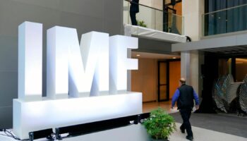 Attendees walk inside an atrium at the 2022 Annual Meetings of the International Monetary Fund and the World Bank Group, Monday, Oct. 10, 2022, in Washington. (AP Photo/Patrick Semansky)