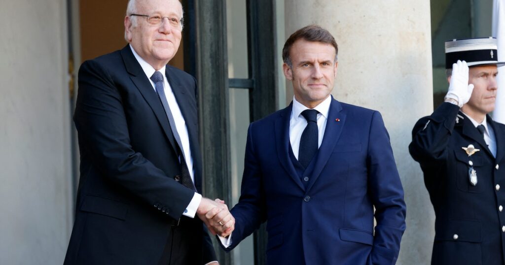 Le président français Emmanuel Macron serre la main du Premier ministre libanais Najib Mikati alors qu'il l'accueille avant leur rencontre au palais présidentiel de l'Élysée à Paris, le 23 octobre 2024.