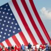 Le drapeau américain flotte au dessus de sympathisants venus assister au meeting où Donald Trump a été la cible de tirs à Butler (nord-est des Etats-Unis), le 13 juillet 2024