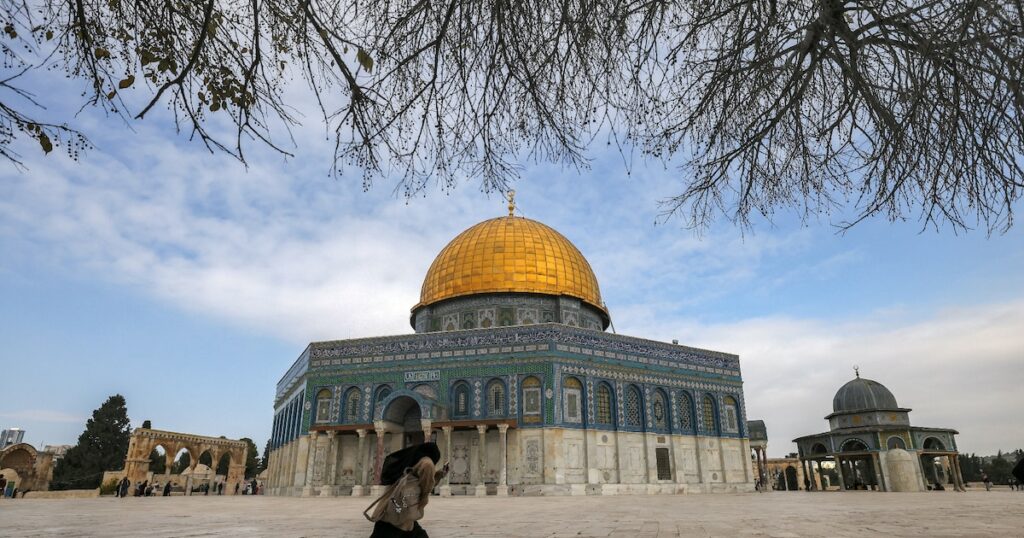 Une femme court devant la mosquée Al-Aqsa, sur l'esplanade des Mosquées, dans la Vieille ville de Jérusalem, dans le secteur palestinien occupé et annexé par Israël, le 3 janvier 2023